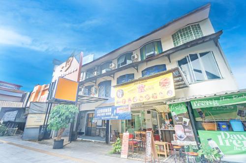 a building with tables and chairs in front of it at Hotel O Bogor Near Museum Peta in Bogor