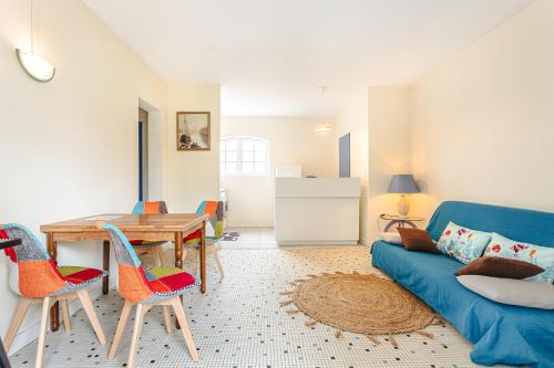 un salon avec un canapé bleu et une table dans l'établissement Longère proche plage et forêt, à Saint-Trojan-les-Bains