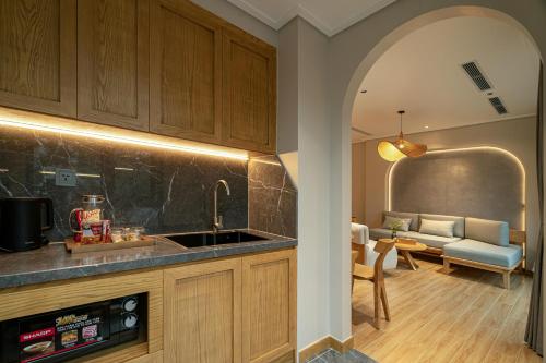 a kitchen with a sink and a living room at Nam Dat Hotel by D'Lecia Ha Long in Ha Long