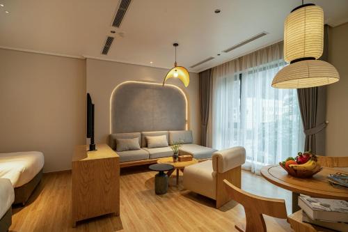 a living room with a couch and a table at Nam Dat Hotel by D'Lecia Ha Long in Ha Long