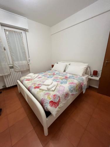 a bedroom with a bed with a floral comforter at Angelica apartment in Sirmione