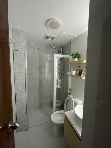 a bathroom with a shower and a toilet and a sink at Lapu2x Studio apartments feels home in Lo-oc