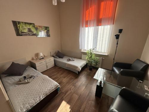 a small living room with a bed and a chair at Pokoje Gościnne Rozbark in Bytom