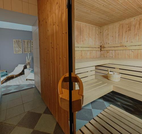a sauna with a wooden wall and a wooden chair at Villa Bleichröder in Heringsdorf