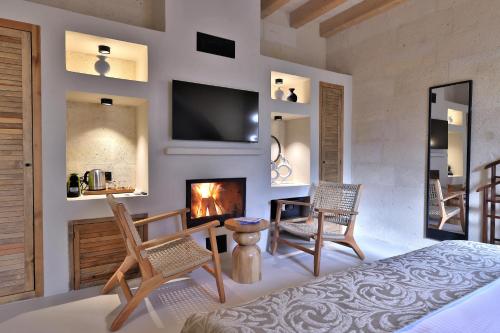 a bedroom with a fireplace and two chairs and a bed at Simurg Cave House in Urgup