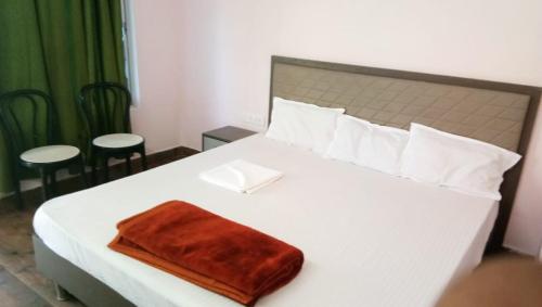 una camera da letto con un letto bianco con una coperta marrone di The Wild Tiger Resort a Jyoti Gaon
