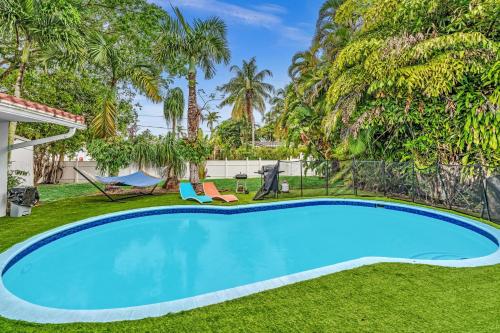 a swimming pool in the yard of a house with palm trees at Luxury Heated Pool Villa Hollywood Beach & Casino in Hollywood