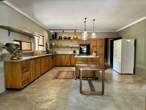 a large kitchen with wooden cabinets and a refrigerator at Ukujabula in Groblersdal