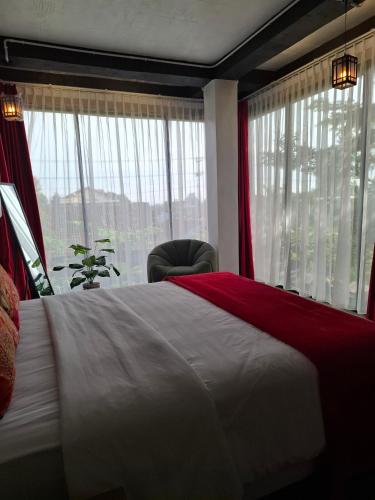 a bedroom with a bed and a chair and a window at Valhalla Boutique Hotel in Salatiga