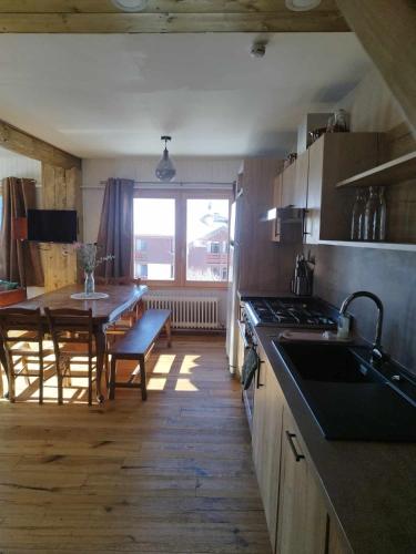 a kitchen with a table and a dining room at Appartement skis aux pieds, à Peisey Vallandry in Landry
