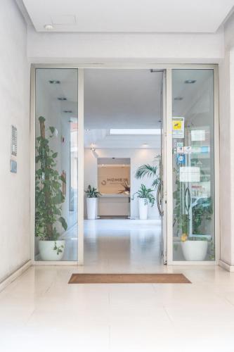 an open glass door with potted plants in a room at Home 15 Residence Hotel in Catania
