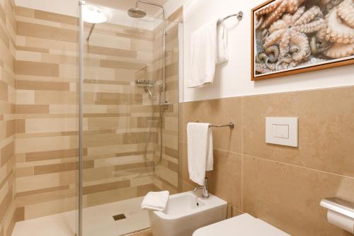 a bathroom with a toilet and a glass shower at Portopiccolo Apartments - Telgatino nel Golfo in Sistiana