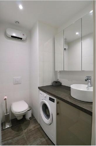 une salle de bain avec une machine à laver et un lavabo dans l'établissement 3 pièces 55m2 - 30 m de la mer, à Nice