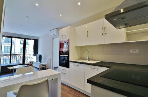 une cuisine avec des armoires blanches et un comptoir dans l'établissement 3 pièces 55m2 - 30 m de la mer, à Nice