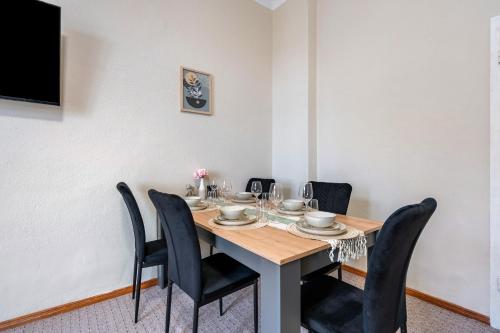 a dining room with a table and black chairs at Bahnhofsnahes Altstadt-Paradies in Cottbus