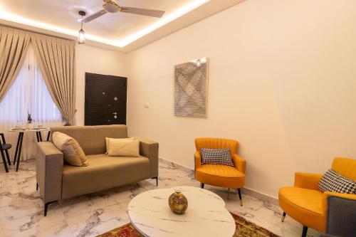 a living room with a couch and chairs and a table at Caros Villa in Adentan