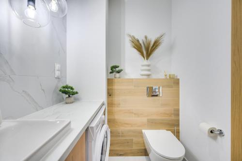 a white bathroom with a toilet and a sink at ReVital Mechelinki by Homeprime Parking Free in Mechelinki