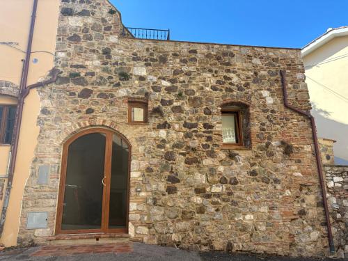 a stone building with a door and a window at Casa Poggivecchi in Castellina Marittima