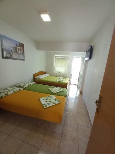 due letti in una piccola stanza con corridoio di Dzenan apartmani a Dobra Voda