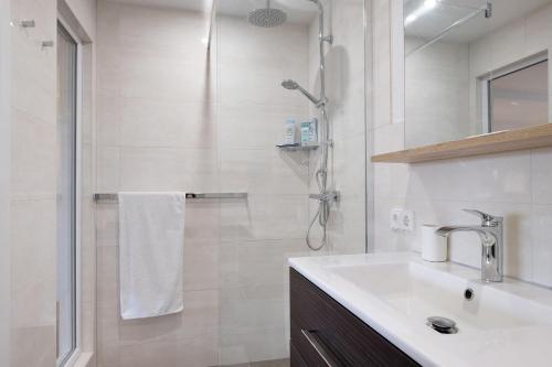 a white bathroom with a sink and a shower at Sonnige Ferienwohnung im Kinzigtal in Wolfach