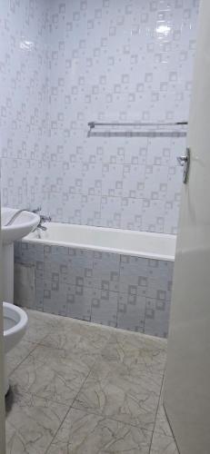 a bathroom with a bath tub and a toilet at Hungwe Apartment in Harare