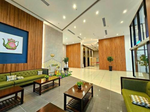 a large living room with green couches and tables at Amber Cove Melaka in Melaka