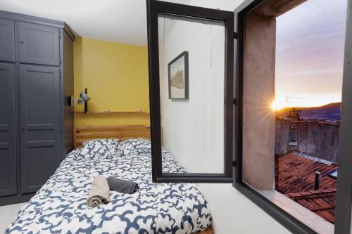 une chambre avec un lit et une grande fenêtre dans l'établissement Unique Studio - Rhone & Mountains Panoramic View, à Valence