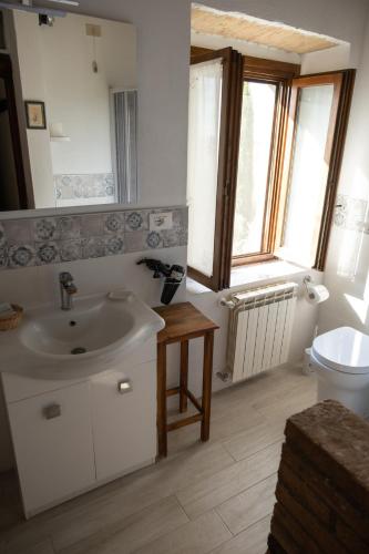 a bathroom with a sink and a toilet at La Canonica in San Giovanni dʼAsso