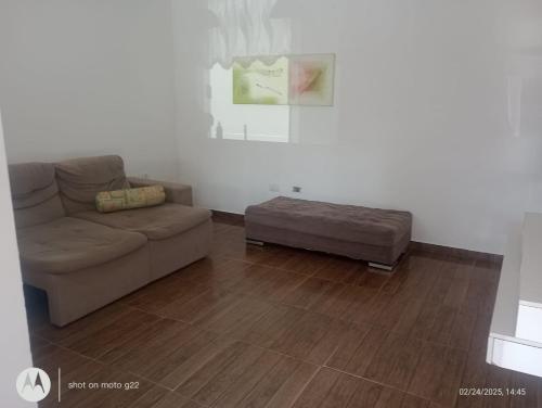 a living room with a couch and a ottoman at Casa de Praia in Pontal do Paraná