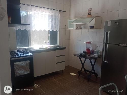 a small kitchen with a sink and a refrigerator at Casa de Praia in Pontal do Paraná