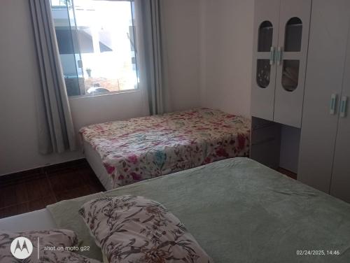 a small room with two beds and a window at Casa de Praia in Pontal do Paraná