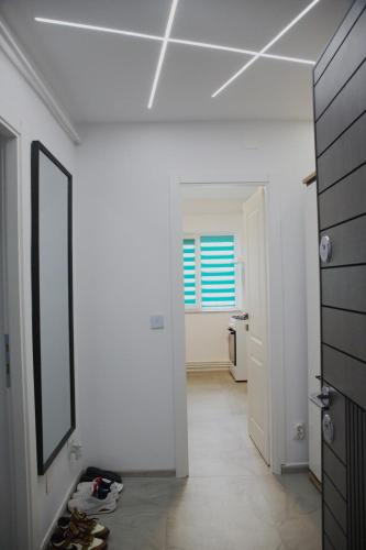a white room with a mirror and a hallway at Romanescu One Apartament in Craiova