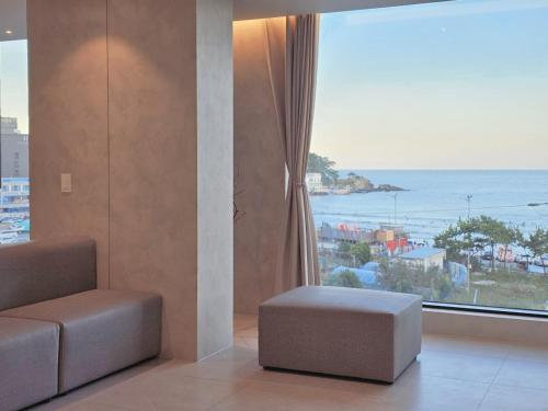 a living room with a view of the ocean at 펜톤나인 해변열차 송정2호점 in Busan