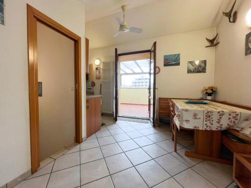a dining room with a table and a kitchen at 48 Trilocale vista mare in Bellaria-Igea Marina