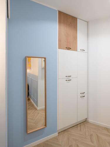 - un miroir mural dans une chambre avec des armoires blanches dans l'établissement Calm and design metro Guichard, à Lyon