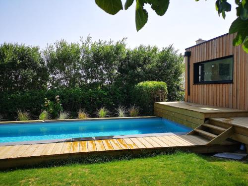 una piscina con terrazza in legno e una casa di Proche des plages, piscine extérieure a Camaret-sur-Mer
