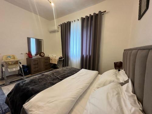 a bedroom with a bed and a window at Vladi's Home in Çorovodë