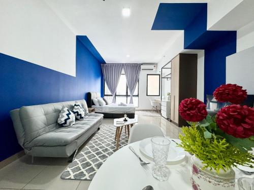 a blue and white living room with a couch and a table at Alinea Suites by Moka in Shah Alam