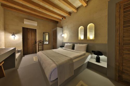a bedroom with a large bed and a bathroom at Simurg Cave House in Urgup