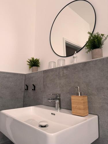Un baño con un lavabo blanco y un espejo. en Studio Apartment im Zentrum mit Parkplatz & neuem Badezimmer, en Magdeburgo
