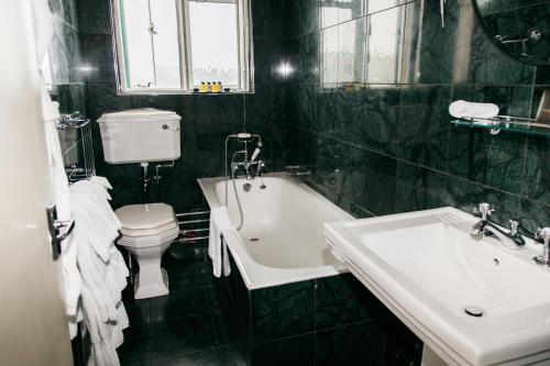 a bathroom with a toilet and a tub and a sink at Burgh Island Hotel in Bigbury on Sea