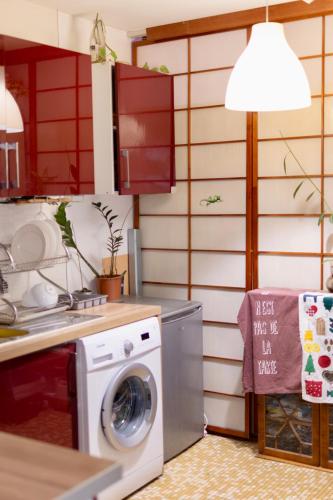 une cuisine avec un lave-linge et une lampe dans l'établissement Une chambre chez habitant, à Colombes