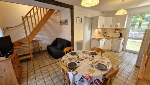 un salon avec une table et une cuisine dans l'établissement Meschers sur Gironde - PETITE VILLA pour un SEJOUR EN FAMILLE en RESIDENCE, à Meschers-sur-Gironde