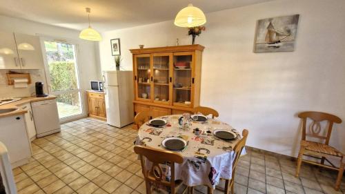 Il comprend une cuisine équipée d'une table et d'un réfrigérateur. dans l'établissement Meschers sur Gironde - PETITE VILLA pour un SEJOUR EN FAMILLE en RESIDENCE, à Meschers-sur-Gironde