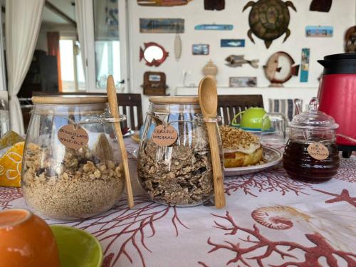 ein Tisch voller Gläser mit Essen und Löffeln in der Unterkunft B&B Cala Pisana (Paola e Melo) in Lampedusa