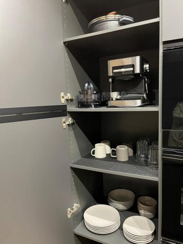 a kitchen with white plates and a coffee maker at Urban Loft Rosal - parking privado in Oviedo