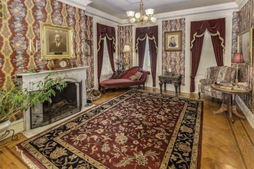 a living room with a fireplace and a rug at The Emig Mansion in York