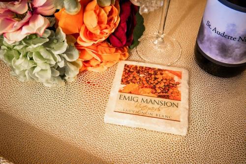a table with a bottle of wine and some flowers at The Emig Mansion in York