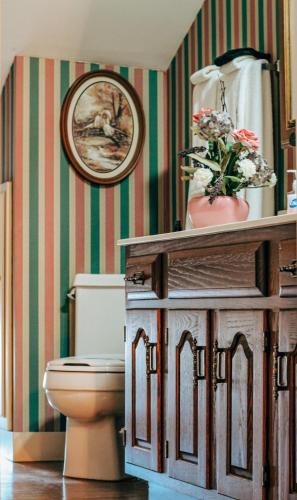 a bathroom with a toilet and a picture on the wall at The Emig Mansion in York