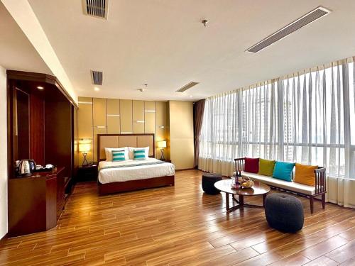 a hotel room with a bed and a couch at Avatar Danang Hotel in Da Nang